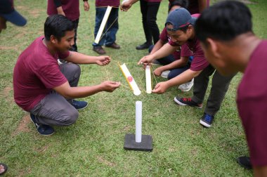 Bogor, 10 Ağustos 2024. Takım oluşturma faaliyetlerine katılan bir grup insan, takım çalışmasını ve iletişimi teşvik eden işbirlikçi oyunlara katılıyorlar. Şirket veya grup dinamiği temaları için ideal.