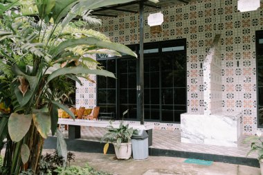 Modern bir ev, parlak siyah cam pencereli, şık ve çağdaş bir tasarımı yansıtan.