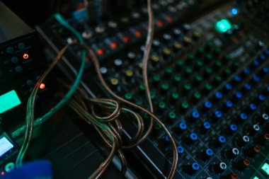 Ses seviyelerini ayarlamak için çeşitli kanalları, düğmeleri ve kaydırıcıları olan bir ses karıştırıcı. Kayıt stüdyoları, canlı performanslar veya yayın ayarları için ideal.