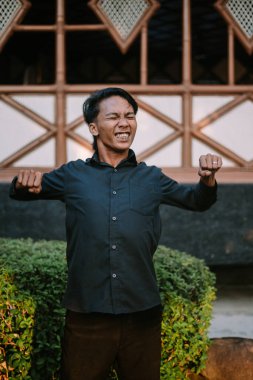 Güneydoğu Asyalı bir adam kalçasını öne doğru iterken sırtını esnetiyor. Çok açık.