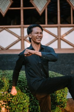 Güneydoğu Asyalı bir adam kalçasını öne doğru iterken sırtını esnetiyor. Çok açık.