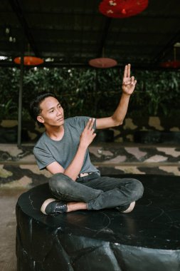 Güneydoğu Asyalı bir adam neşeli bir şekilde dans ediyor, vücut dili ve neşeli bir ifadeyle hareket halinde. Dans et.