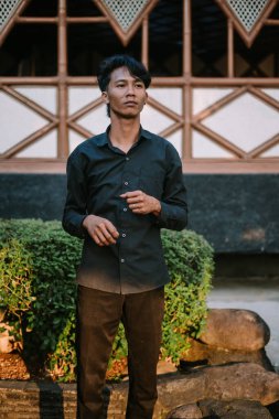 Güneydoğu Asyalı adam kendine güveni ve tarzıyla havalı bir poz veriyor. Moda, kendine güven ve modern yaşam tarzı için mükemmel bir tema..