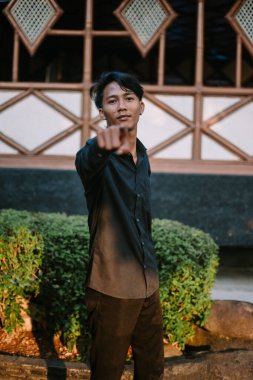 Güneydoğu Asyalı adam vurgu yaparak odak ya da yön veriyor. Liderlik, eğitim ya da iddialı iletişim gibi kavramlar için ideal..