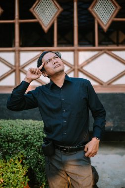 Düşüncelere dalmış, düşüncelere dalmış Güneydoğu Asyalı bir adam. Karar verme, problem çözme veya yaratıcılık temaları için mükemmel.