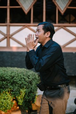 Şaşırmış bir ifadeyle Güneydoğu Asyalı adam, gözleri açık ve ağzı açık. Şok, beklenmeyen anlar ya da tepkiler için ideal