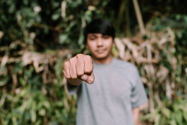 Güneydoğu Asyalı bir adam oyuncu ya da kendine güvenen bir hareketle kafasını gösteriyor. Kişiliğini ve tutumunu ifade ediyor. Kendini ifade etme ve bireysellik temaları için ideal.