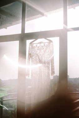 Bir ağaç dalına asılmış zarif bir gelinlik eşsiz ve güzel bir açık hava ortamı yaratıyor.