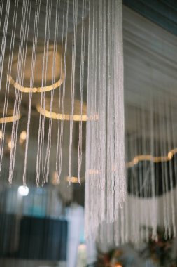 Beyaz perdeleri ve ışıkları olan dekoratif tavan kurulumu.