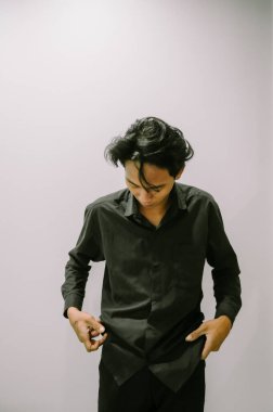 Adam siyah gömleğini düzeltiyor, minimalist bir geçmişi var..