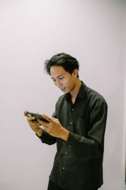 Gezici bir oyuna dalmış, boş zamanlarının tadını çıkaran genç bir adam..