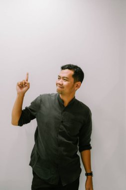 Genç bir adam yukarıya doğru işaret eder, yukarıdaki bir şeye dikkat çeker..