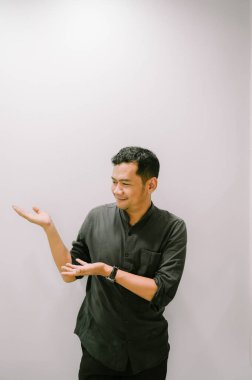 Genç bir adam eliyle bir şey gösterir ya da gösterir..