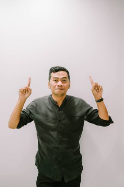 Genç bir adam yukarıya doğru işaret eder, yukarıdaki bir şeye dikkat çeker..