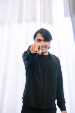 Koyu renk elbiseli bir adam kameraya doğrudan kararlılıkla bakar. Doğrudan bağlanma ve meydan okuma hissi yaratır. Davranışlarına odaklanmak, sorumluluk, seçim ya da birini bir şeyin parçası olmaya davet etme temalarını aktarır..