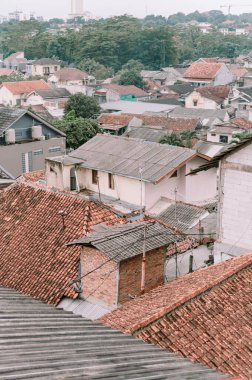 Büyüleyici bir panoramik çekimle şehrin çatılarının geniş açısını yakalayın. Görüntü bölgenin mimari çeşitliliğini vurguluyor, konut evleri ve kentsel yapıları geniş bir manzaraya harmanlıyor. Housi yoğunluğu gösteriliyor