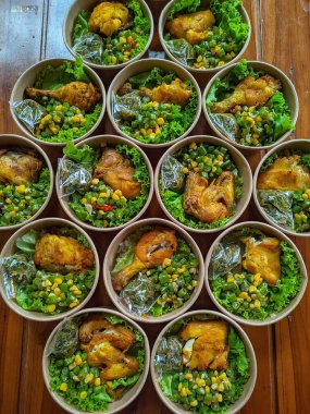 İçinde kızarmış tavuk, sebze salatası ve diğer mezelerin bulunduğu ayrı ayrı yemek kutuları. Yemek servisi, sağlıklı beslenme ya da paket servis konsepti için uygun. Taze malzemeler, doğaüstü güçler için dengeli ve besleyici bir yemek oluşturur.