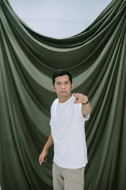 Odaklanmış bir adamın portresi yoğun bir bakışla izleyiciyi işaret ediyor, zeytin yeşili bir zemin üzerine kurulmuş. Doğruluğu ve ciddi ifadesi, liderlerle ilgili kavramlar için uygun, anlık bir bağlantı ve komuta duygusu yaratıyor.