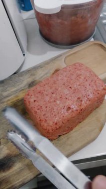 İşlenmiş etin sıfırdan hazırlanmasına tanık olun. Eti, ahşap bir tahtanın üzerinde dilimlendiği gibi gözlemleyin. Dokusunu ve mutfak kullanımına hazır olduğunu gösterin.. 