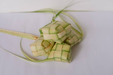 Ketupat, geleneksel pirinç köftesi, palmiye yapraklarından örülmüş ve buğulanmış. Güneydoğu Asya 'da Kurban Bayramı gibi bayramlarda popülerdir. Beyaz arkaplan ile Ketupat üzerine seçmeli odak. 