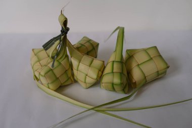 Ketupat, Ramazan Bayramı 'nda popüler olan pirinç köftesidir. Hindistan cevizi yapraklarından örülmüş ve pirinçle dolu olan bu lezzetli yemekler, Güneydoğu Asya kutlamalarının temel taşlarından biri. Beyaz bir arkaplanda, eşsiz şekilleri ve şenlikli görünüm temsilcileri.
