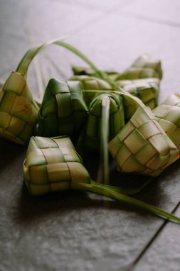 Ketupa yakın çekim, geleneksel pirinç köftesi, palmiye yapraklarından yaratıcılıkla örülmüş. Bayram ve Ramazan aylarında sıklıkla kullanılan bu Asya mutfağı bayram kutlamalarını sembolize ediyor. Taze malzemeler ve titiz ambalajlar bir lezzet yaratıyor.