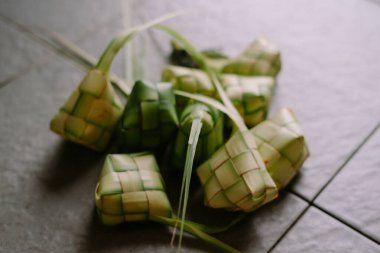 Yakın çekim ketupat, geleneksel pirinç köfteleri genç palmiye yapraklarından ustalıkla örülmüş. Bunlar genellikle Güneydoğu Asya 'daki Kurban Bayramı gibi bayramlarda kullanılıyor. Mutfak geleneklerine kültürel bir bakış sağlıyor..