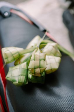 Ketupat 'ın yakın çekimi, Güneydoğu Asya' da popüler olan geleneksel pirinç köftesi. Bu karmaşık örülmüş palmiye yaprağı kesesi buharda pişmiş pirinç içeriyor ve eşsiz bir aşçılık deneyimi sunuyor. Kutlamalar sırasında keyifli bir şenlik..