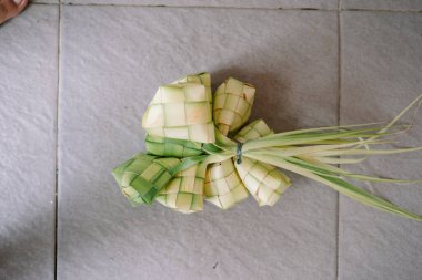 Ketupat, örülmüş palmiye yapraklarına sarılmış geleneksel pirinç köftesi. Güneydoğu Asya 'da özellikle bayram kutlamalarında popülerdir. Bu ayırt edici yemek, kültürel önemi ve aşçılık sanatını temsil ediyor. Festival geleneğini sembolize etmek için mükemmel.