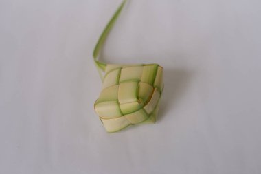 Beyaz arka planda izole ketupat. Ketupat, genellikle Kurban Bayramı ve Ramazan Bayramı gibi bayram kutlamalarında servis edilen örülmüş palmiye yaprağı kesesinde pişirilmiş geleneksel bir Güneydoğu Asya pirinç köftesi. Endonezya 'da, Malezya' da, Singapur 'da ve 