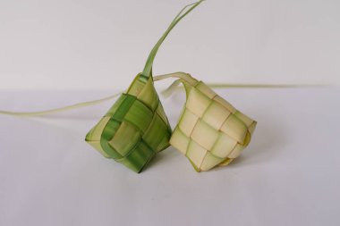 Örülmüş palmiye yapraklarından yapılan iki ketupat pirinç köftesi, Güneydoğu Asya 'da özellikle Kurban Bayramı veya Hari Raya döneminde popüler olan bir kutlama yemeği. Geleneksel dokuma stillerini gösteriyor. Festivallerin kültürel sembolü..