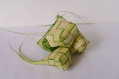 Güneydoğu Asya 'da özellikle Kurban Bayramı gibi bayramlarda popüler olan geleneksel pirinç köftesi olan üç Ketupat' ın stüdyo çekimi. Pirinç örülmüş palmiye yapraklarına sarılır ve kaynatılır. Eşsiz bir doku ve lezzet yaratır. Bir ovada servis edildi.