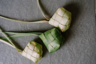 Özellikle bayram kutlamalarında olmak üzere Güneydoğu Asya 'da popüler olan geleneksel pirinç hamur tatlısı olan üç Ketupat' ın yakın çekimi. Bu dokuma palmiye yaprağı kesesi pirinçle dolu ve kaynatılmış, eşsiz bir doku ve lezzet sunuyor. Memnuniyeti simgeliyor.