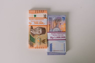 İki yığın Endonezya Rupiah banknotu. Finansal zenginliği, birikimleri ve ekonomik faaliyetleri temsil ediyor. Endonezya 'da para, döviz ve mali işlemler.