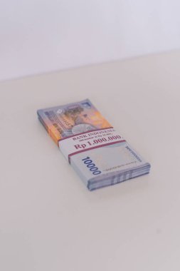 Bir yığın Endonezya Rupiah banknotunun kağıt bantla korunan yakın görüntüsü. Endonezya 'da finansal zenginliği, yatırım fırsatlarını ve para işlemlerini sembolize eder.