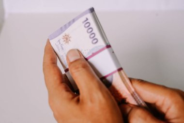 Endonezya Rupiah banknotlarını tutarken yakın plan çekimler. Endonezya 'da finans, ekonomi, yatırım, bankacılık, döviz kuru ve zenginlik kavramı.