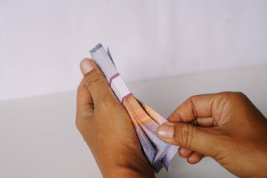 El ele tutuşup beyaz bir arkaplanla bir yığın banknot sayacağım. Zenginlik, yatırım, mali planlama, bankacılık ve işletme kavramlarını gözler önüne serer.