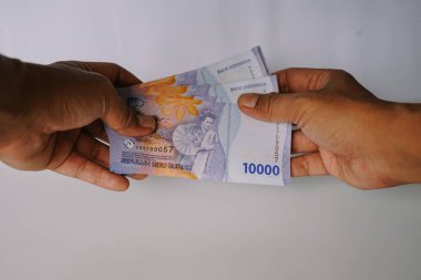 Endonezya Rupiah banknotlarına yakın çekim. Finansal işlemleri, döviz kurlarını ya da ödemeleri gösteriyor. İş, yatırım ve Endonezya ekonomisini temsil ediyor.