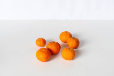 Beyaz bir yüzey üzerinde taze mandalinaların stüdyo çekimi. Sağlıklı bir yaşam tarzı, dengeli beslenme veya vitamin zengini besin kaynakları için idealdir..