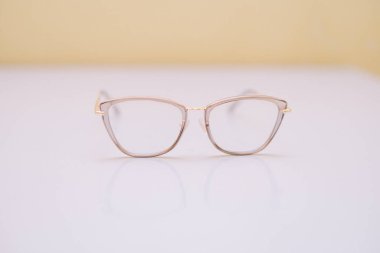 Yumuşak bir zemin üzerinde el değmemiş beyaz bir yüzey üzerinde duran zarif bir çift kedi gözü gözlüğü. Şeffaf çerçeveler optik moda ve şık tasarımı vurguluyor. Göz giyimi, vizyon bakımı ya da kişisel stil gibi konular için uygun.