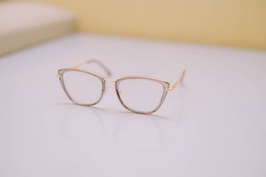 Parlak bir yüzeyde altın çerçeveli zarif kedi gözlüğü. Moda aksesuarı ya da açık görüşün sembolü olarak mükemmel olan zarif bir sofistike ve modern tasarım hissi uyandırıyor..