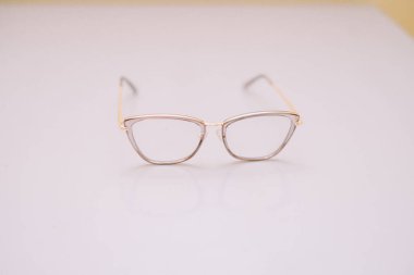Zarif metalik çerçeveli zarif gözlükler, temiz, minimalist bir stüdyo ortamında sunuluyor. Görüş düzeltme, moda ve modern yaşam tarzı temalarını iletmek için mükemmel..