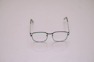 Bir çift gözlük el değmemiş beyaz bir yüzeyde duruyor. Görüntü, görme, okuma, berraklık ve entelektüel arayışlarla ilgili kavramları aktarır. Minimalist stil, basitliğe odaklı tasarımlar için uygun hale getirir..