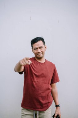 Etkileyici bir adam işaret parmağını kameraya doğrultuyor. Bu, izleyiciyle doğrudan teması vurguluyor