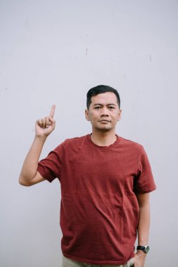 Genç adam yukarı bakıyor, bir konsept sunuyor ya da dikkat çekiyor. Bir fikir veya tavsiye göstergesi. Basit beyaz bir arkaplanda izole edilmiş..