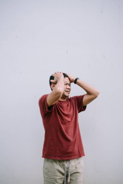 Kafasını tutan endişeli bir adam. Stres ve kaygılarını ifade eden bir yetişkinin portresi.