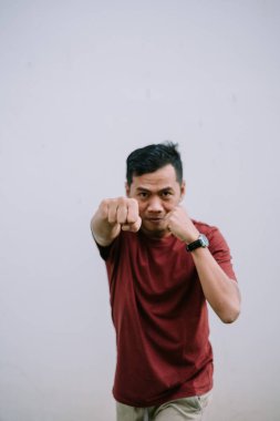 Yumruklarını sıkmış, kararlı ve rekabete hazır bir şekilde dövüşen bir adam.