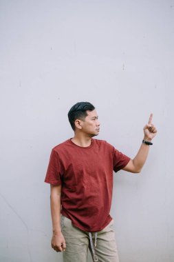 Bir adam beyaz bir duvarın yakınını işaret ediyor. Yön ve fırsatçılığın sembolü.