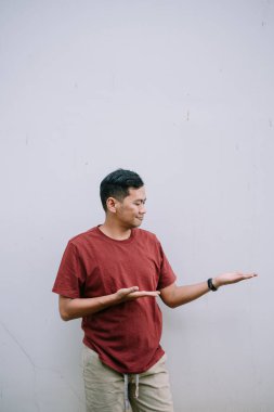 Asyalı bir adam elini duvara dayayıp ürününüz veya reklamınız için arka planda beliriyor.
