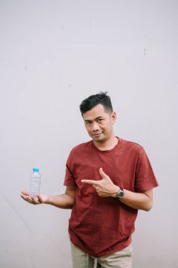 Bir adam, sağlıklı ve sürdürülebilir bir yaşam tarzını destekleyen, yeniden kullanılabilir bir su şişesi gösterir.. 